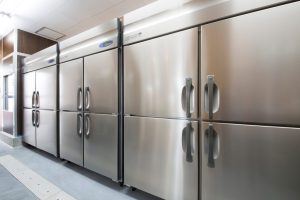 A row of three stainless steel commercial freezers