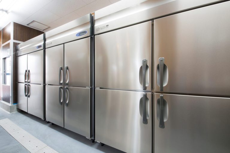 A row of three stainless steel commercial freezers